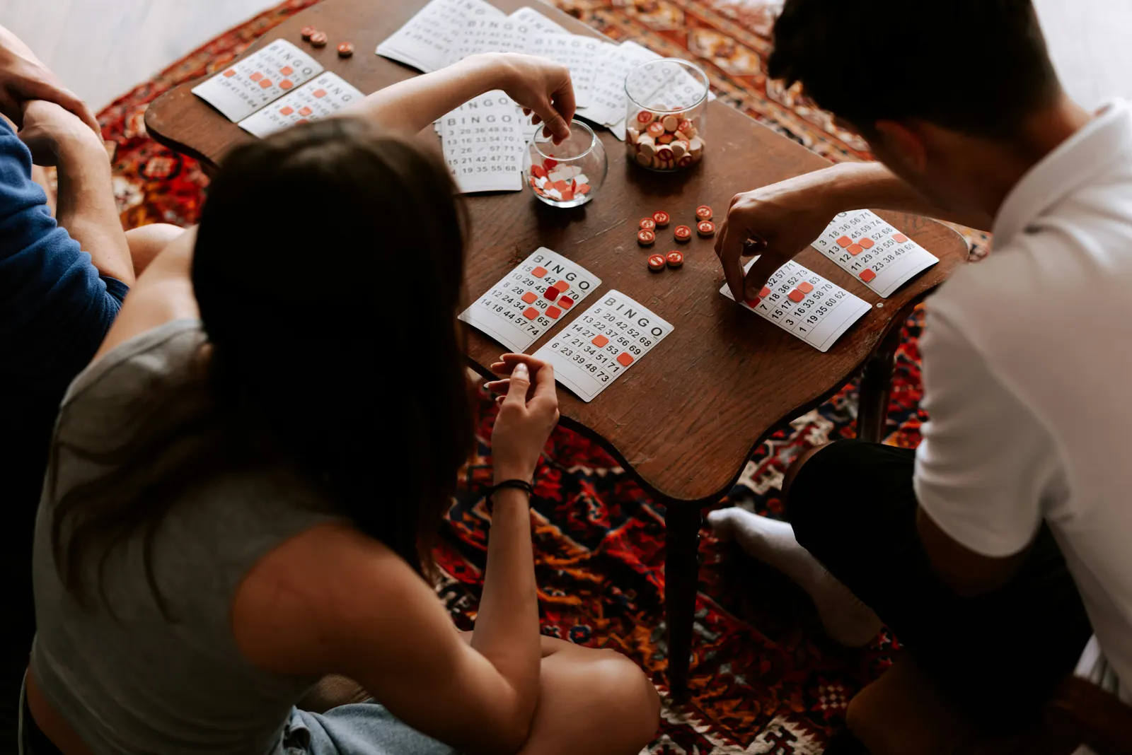Friends playing bingo around a small table at home
